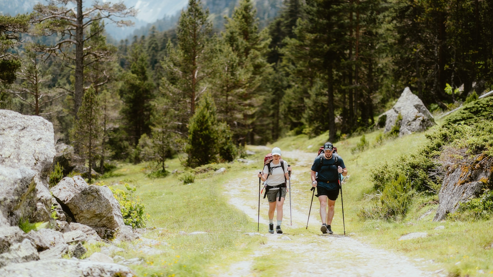 A couple of people walking down a dirt road